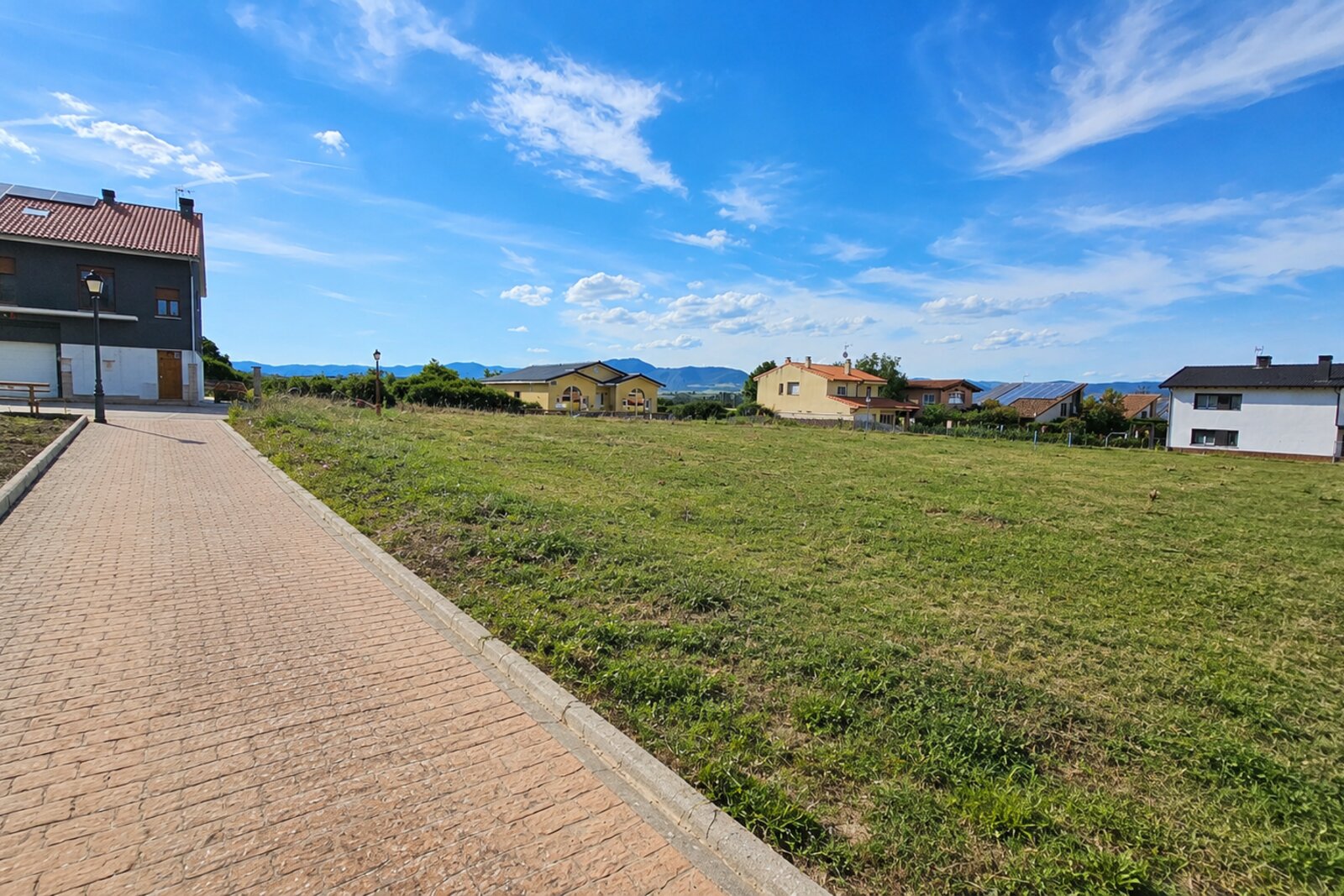 Paseo del ensanche con vivienda unifamiliar aislada en perspectiva y horizonte abierto